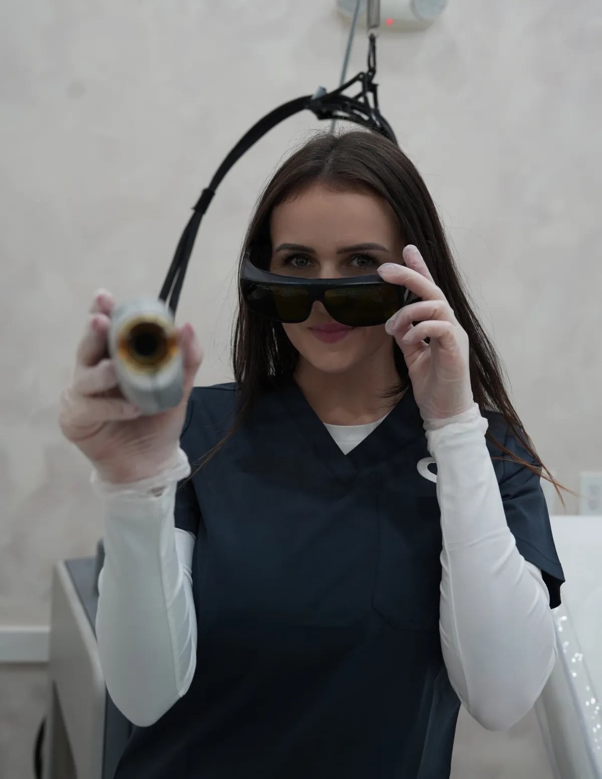 Semper specialist in protective goggles holding the laser handpiece